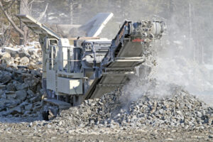 A generalized image of a rock crusher as it crushes large chunks of rock into smaller pieces